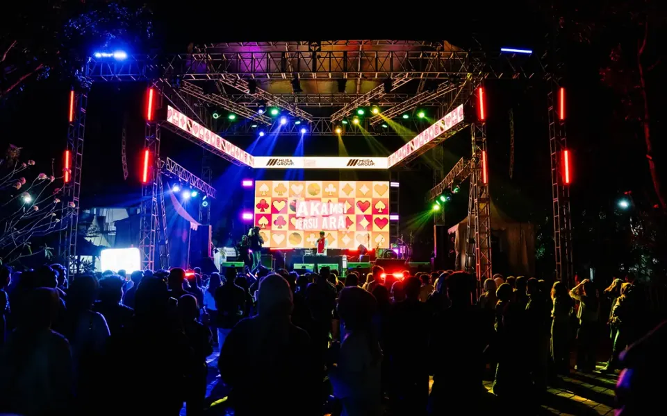 A concert stage at night with the crowd filling the front